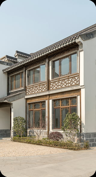 Exterior view of a two story building with traditional architectural details, featuring intricate wood balcony railings and large windows after an exterior renovation tg renovations