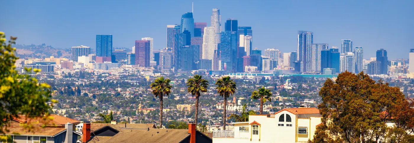 Wide panoramic view of the Los Angeles skyline and surrounding urban landscape under a clear blue sky as seen from Kenneth Hahn State Park tg renovations